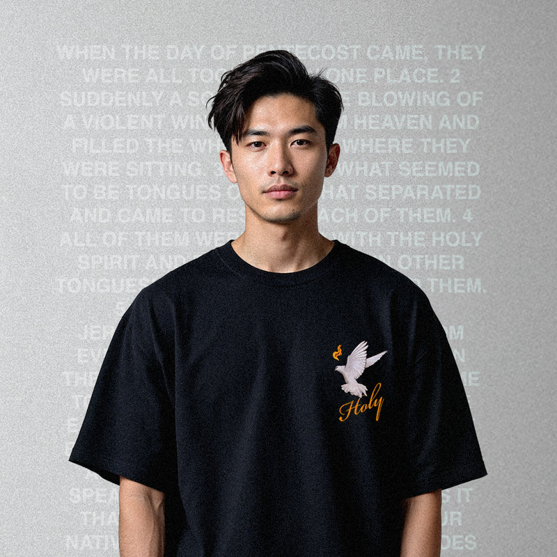 Person wearing a Faith based clothing brand black t-shirt with a dove design and 'Holy' text on a gray background with text overlay.